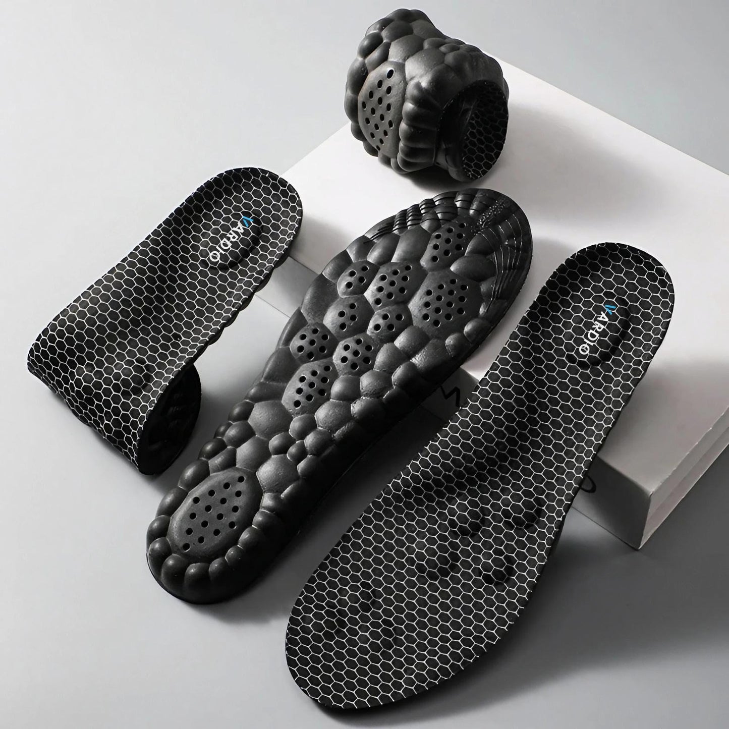 Black honeycomb-patterned insoles with cushioned, ventilated soles for foot support